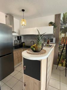a kitchen with a bowl of fruit on a counter at Ti Paradis 1 in Les Trois-Îlets