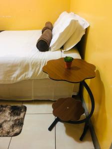 a bed with a table next to a bed at Innovative Hospitality in Gaborone