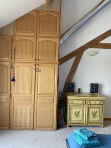 a room with wooden cabinets and a bed and a desk at Poulou Pyrénées in Gelos