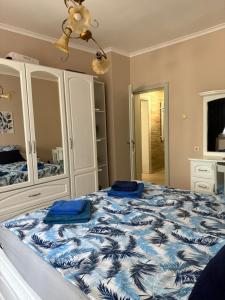 a bedroom with a bed with a blue and white comforter at Cozy apartment in Haskovo
