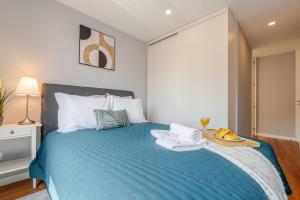 a bedroom with a blue bed with a tray of food on it at Stylish & Bright Apartment by HostWise in Porto