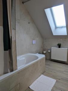 a bathroom with a large bath tub with a skylight at City und Natur - Ferienwohnung an der Itz in Coburg +2 photos