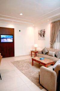 a living room with a couch and a table at Al Quba Palace Serviced Apartments in Riyadh