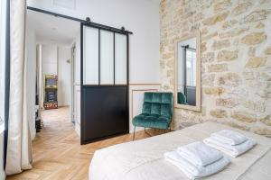a bedroom with a bed and a green chair at Design Loft for 7 guests in Sentier in Paris