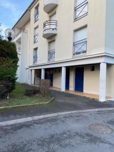 a white building with blue doors and a parking lot at Studio Galerie 473 L'art de vivre à Metz in Metz