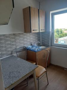 una cucina con tavolo, sedie e lavandino di Apartament Flacara a Arad Altre 3 foto