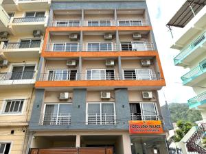an apartment building with balconies and a sign on it at Hotel Uday Palace in Rishīkesh +4 photos