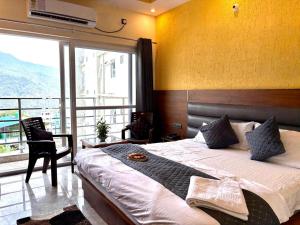 a bedroom with a bed and a large window at Hotel Uday Palace in Rishīkesh