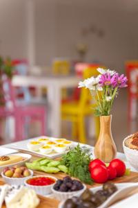 una mesa con platos de comida y un jarrón con flores en Hotel Tuna en Akcay