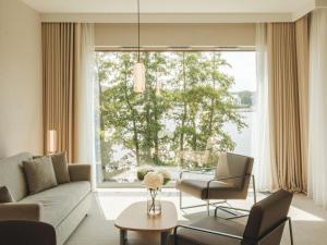a living room with a couch and chairs and a large window at GrandHotel Tiffi in Iława
