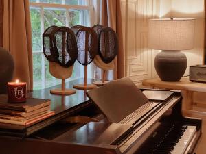 a room with a piano and a table with a lamp at Berkshire Vacation Rentals 1900s Factory Turned Modern Berkshires Retreat in Great Barrington +59 photos
