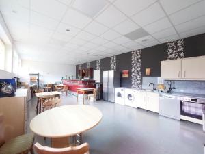 a large kitchen with tables and chairs in it at Nibelungen-Stubb mit einer Gemeinschaftsküche 