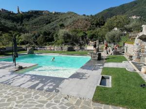 a pool with people swimming in it with mountains in the background at Casa Gardan in Levanto