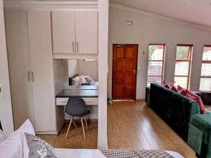 a living room with a couch and a desk at Luxury Studio in Fourways in Sandton