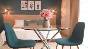 a dining room with a table and two blue chairs at Hotel Quinta de Cabecera in Bucaramanga