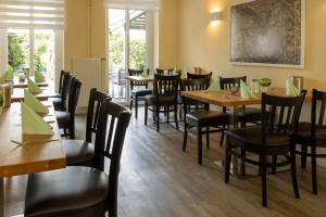 a dining room with wooden tables and chairs at Hotel Rendsburg in Rendsburg