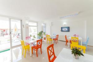a dining room with brightly colored tables and chairs at Hotel Tuna in Akçay