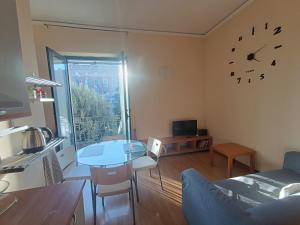 a living room with a table and a clock on the wall at Maria Carolina Suite in Caserta