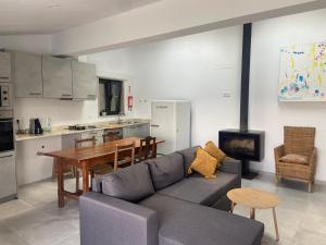 a living room with a couch and a table and a kitchen at Casa de Miguel Chôco in Trancoso
