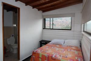 a small bedroom with a bed and a window at HOTEL EL PUNTOS sas in Medellín