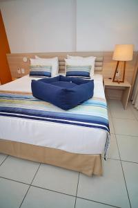 a bed with blue pillows on it in a room at Beach Class Convention By MAI in Recife
