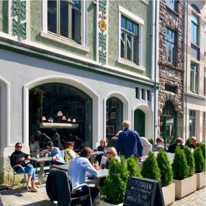a group of people sitting at tables outside a building at Ålesund Central Apartment in Ålesund +9 photos