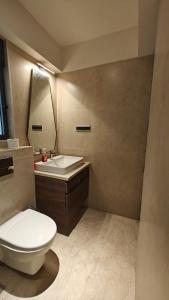 a bathroom with a white toilet and a sink at VIVEBNB 1 BHK Bandra Kurla Complex in Jāmb