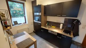 a small kitchen with black cabinets and a table at Kaiserpfalzquartier in Goslar