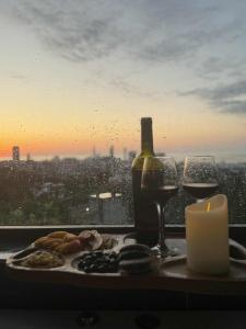 a table with a candle and wine glasses and a window at chill in batumi in Batumi +7 photos