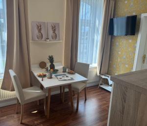 a dining room with a white table and chairs at Apartment-Hotel Perle am Bodden in Ribnitz-Damgarten