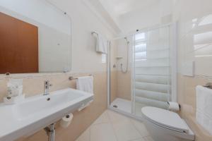 een badkamer met een wastafel, een toilet en een douche bij Hotel Sole in Rosolina Mare