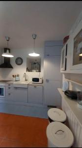 Una cocina blanca con inodoro y fregadero. en Casa da Oliveira, en Ponte de Lima