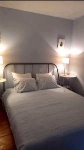 Una cama con dos almohadas y dos lámparas en un dormitorio. en Casa da Oliveira, en Ponte de Lima 33 fotos más