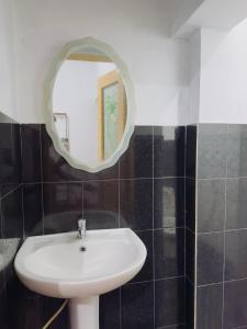 a bathroom with a white sink and a mirror at New Pearl Guest Inn in Badulla +5 photos