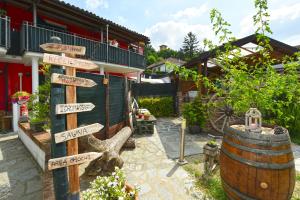 a directional sign in a garden next to a barrel at CASA APPARTAMENTO VACANZE La fermata delle rondini in Castello di Annone