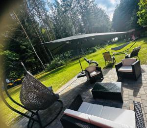 an outdoor patio with chairs and an umbrella at Dom z dużym tarasem nad jeziorem na wyłączność in Krasnopol