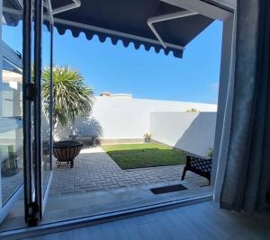 an open door to a patio with a table and a bench at A Lighthousee delight in Swakopmund
