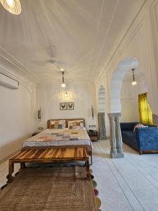Un dormitorio grande con una cama y un sofá. en The Amoli Haveli, en Jaipur
