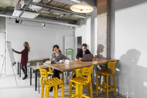 two people sitting at a table with a laptop at Domeq FREE Parking, Gym, Co-working and Terrace in Komárov