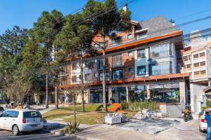 a building on a street with cars parked in front at Edificio Diamond Seasons in Gramado