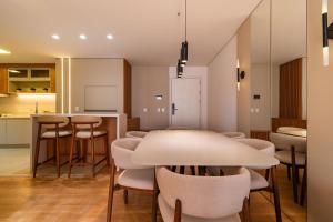 a kitchen and dining room with a table and chairs at Edificio Diamond Seasons in Gramado