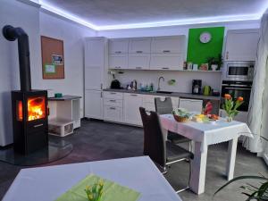 a kitchen with a fireplace and a table and a stove at Pension Weitblick in Stehla