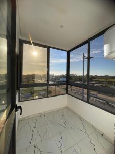 a room with windows and a view of the city at Apparemment propre pour les familles in Casablanca