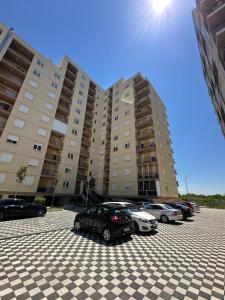 a parking lot with cars parked in front of large buildings at Casa Del Mar 2 in Shëngjin