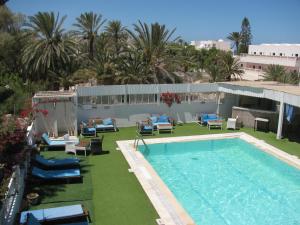 a swimming pool with chaise lounge chairs and a resort at Dar Salem in Djerba