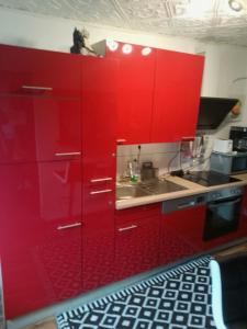 a red kitchen with a sink and red cabinets at Happy Villa Ferienhaus in Olsberg
