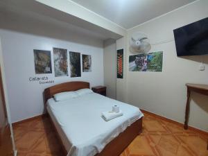 ein Schlafzimmer mit einem weißen Bett und einem Ventilator in der Unterkunft Hostal MonteVerde in Nueva Cajamarca