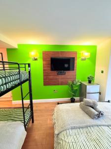 a room with two bunk beds and a green wall at Chiswick Guest Rooms in London +52 photos