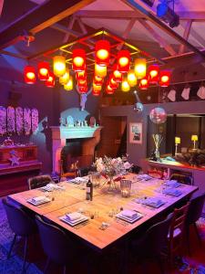 een lange tafel in een kamer met rode lichten bij Gîte à la ferme in Houplin-Ancoisne