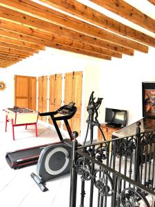 een kamer met een fitnessruimte met een loopband en een tafel bij Gîte à la ferme in Houplin-Ancoisne